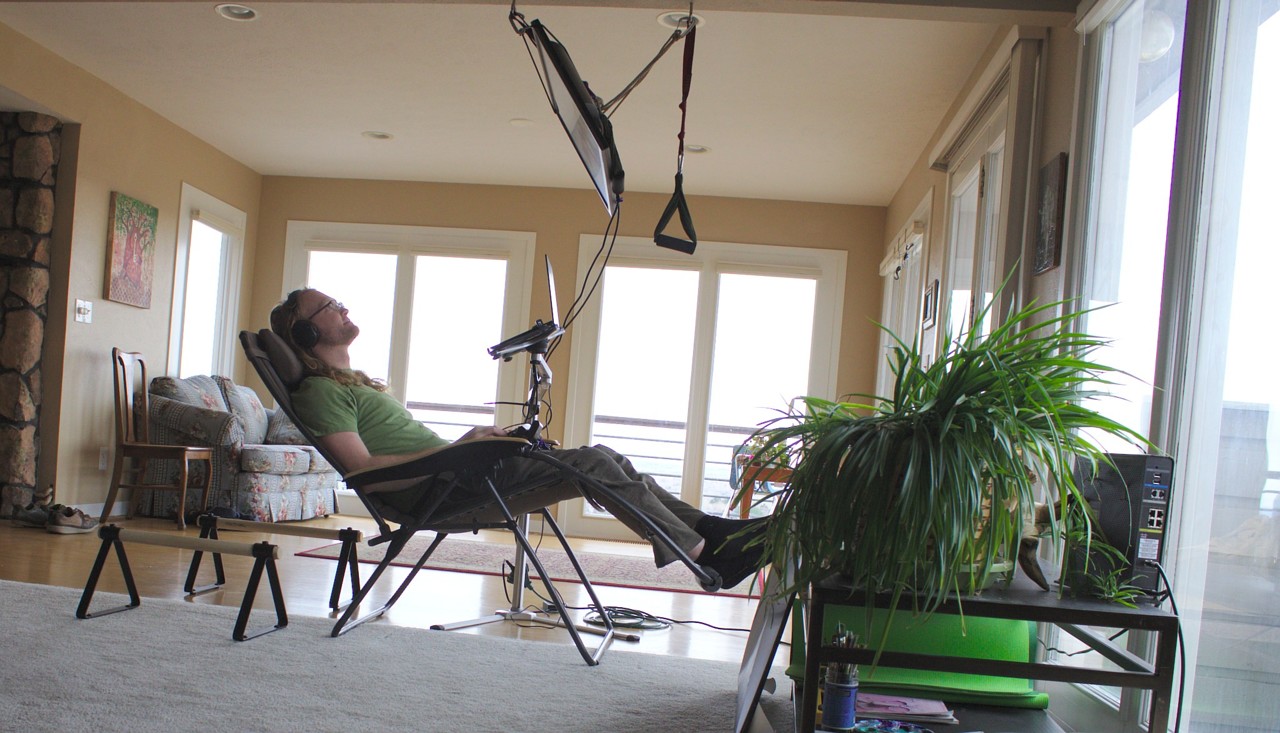photo of a recliner with a monitor suspended by rope