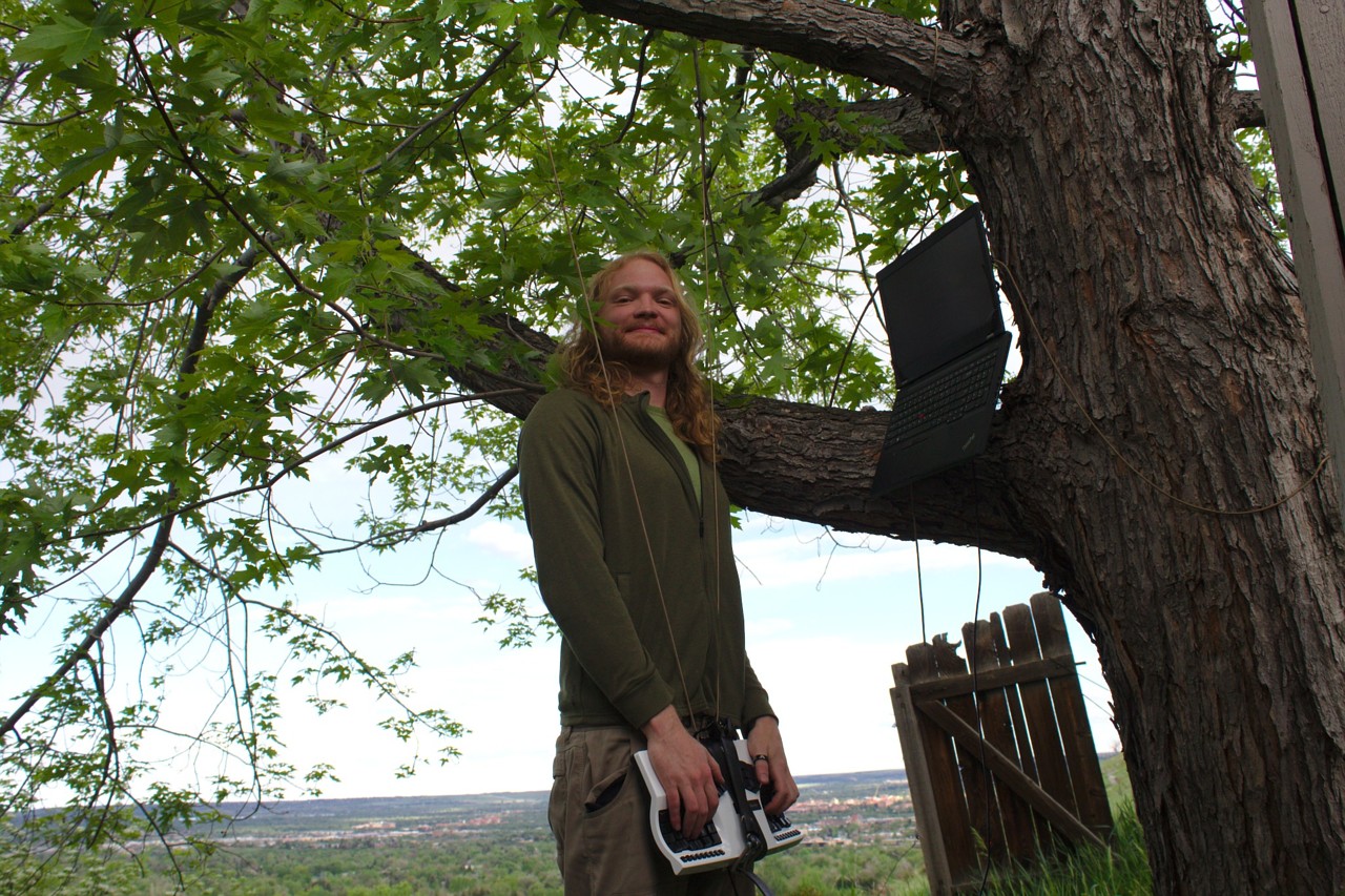 photo of me using a kinesis advantage keyboard suspended from tree